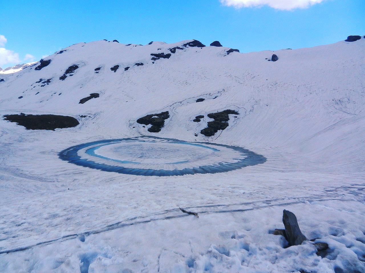 frozen bhrigu lake with water forming blue ring on outer side of lake