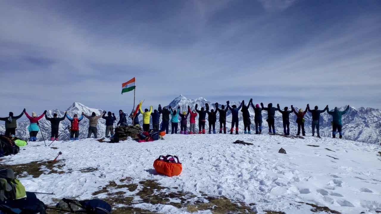 tricolour fly high with fellow trekkers holding hands high to the beauty of himalaya