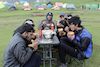 trekkers eating maggie with colourful tents pitched on backside at bedni bugyal campsite 