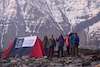 on the foot of huge himalayan mountain trekkers standing near tent
